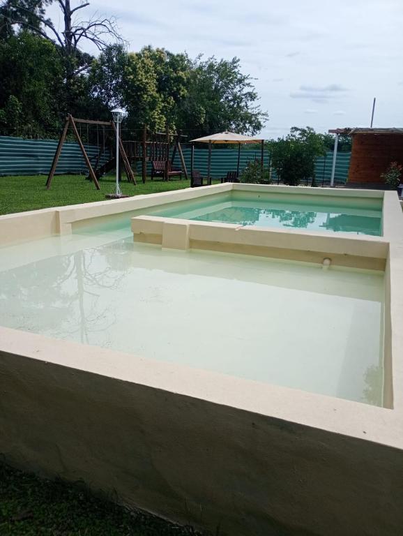 a swimming pool in a park with a playground at Quinta La Soñada eventos luján in Luján