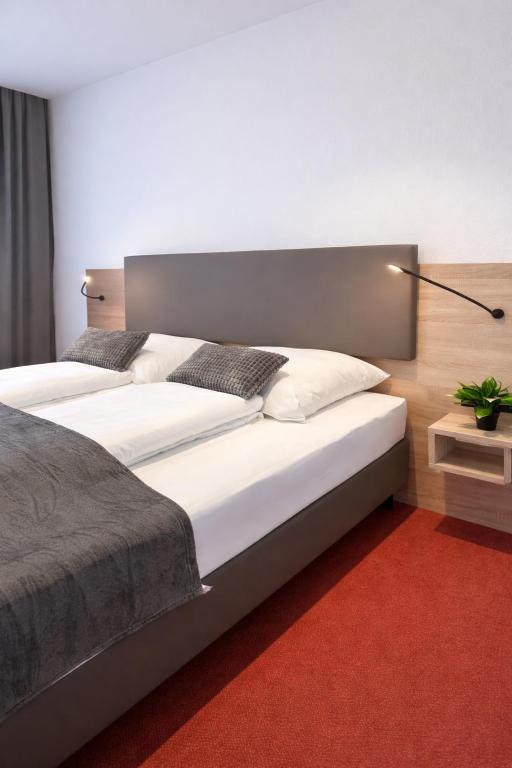 ein Schlafzimmer mit zwei Betten und einem roten Teppich in der Unterkunft Hotel Vorburg - Free Parking - Bei Hamburg in Trittau