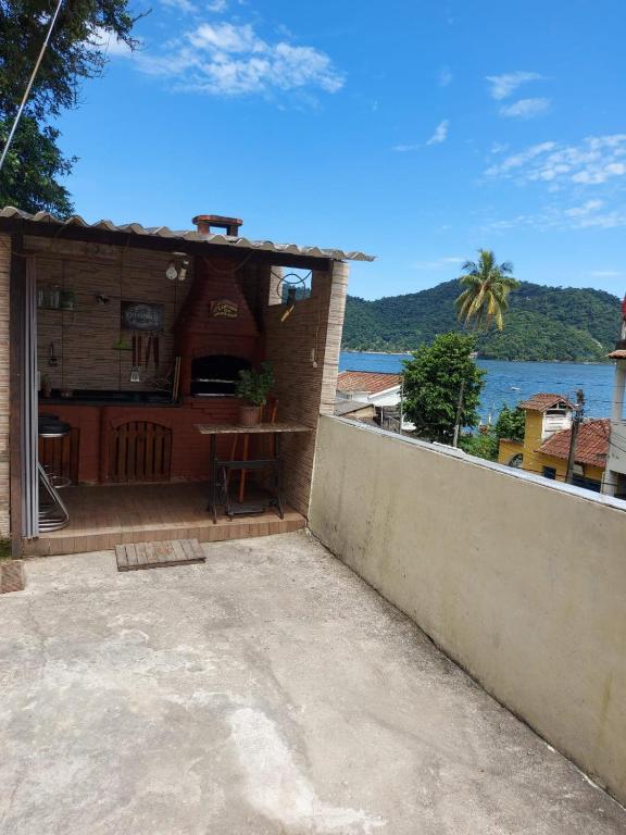 a house with a patio with a view of the water at Recanto na Praia com Vista Mar in Mangaratiba