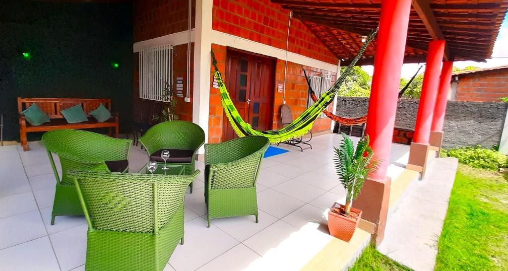 a patio with chairs and a hammock on a house at Casa de Temporada D'Amaro in Santo Amaro