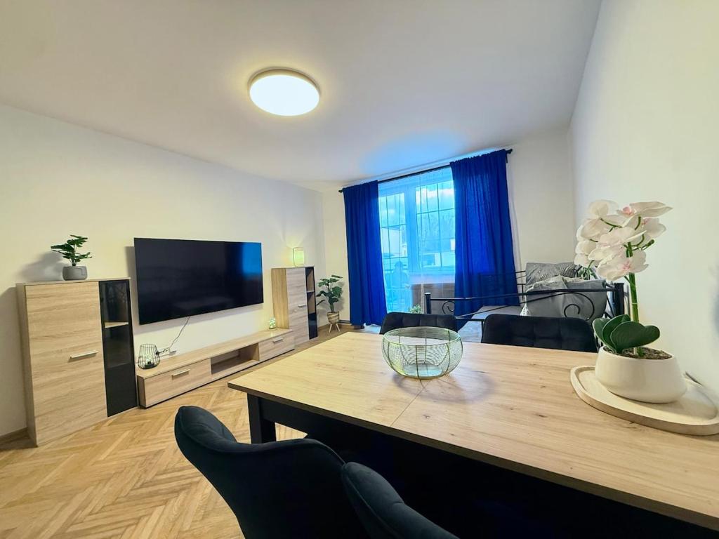a living room with a table and a flat screen tv at Duchcov Apartments in Teplice