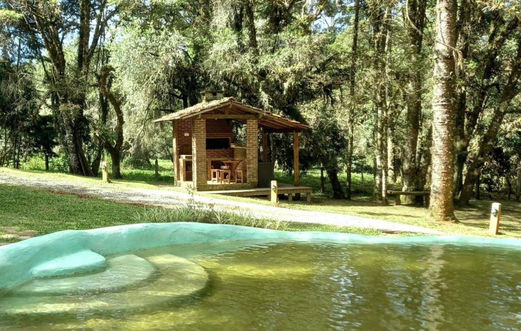 a small cabin next to a body of water at Rio Privativo, Piscina e Starlink - Casa Terras de Minas in Gonçalves