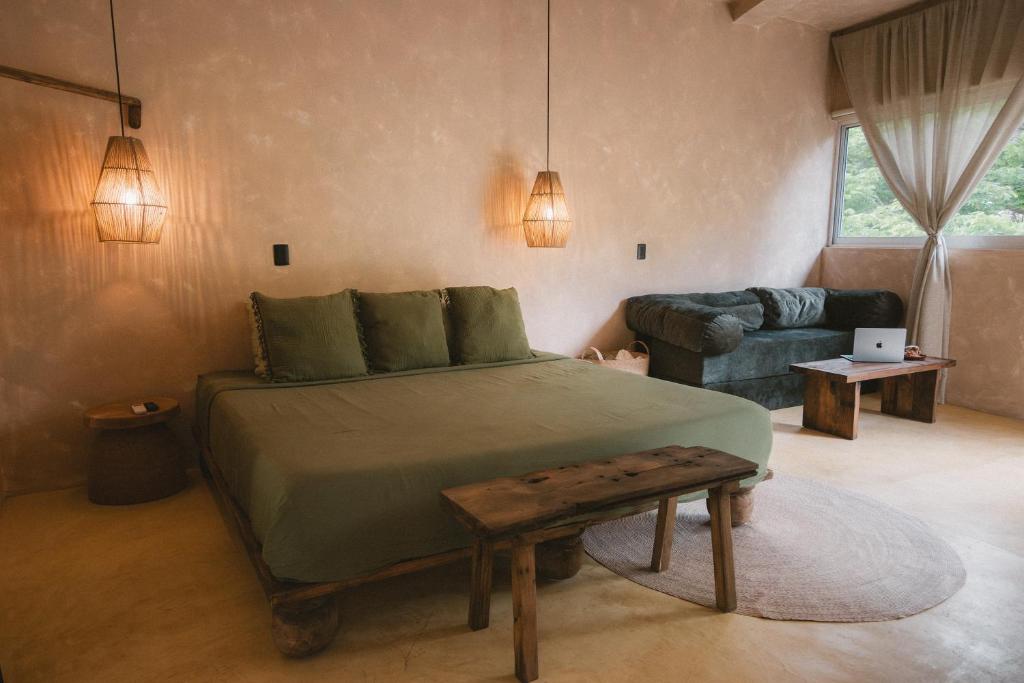 a bedroom with a large bed and a couch at Ánimo Perro in Sayulita