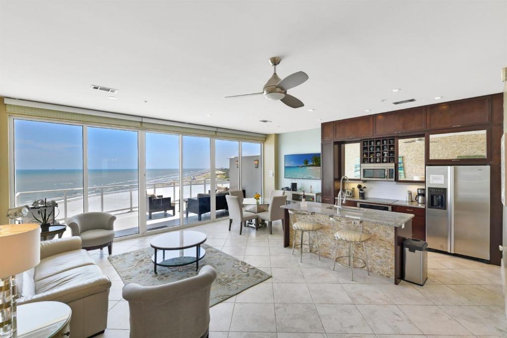 a kitchen and living room with a view of the ocean at XL Terrace, Lazy River, I-O Pools, Game Room, Spa, Beach, Luxury 2-2 Penthouse! in Galveston