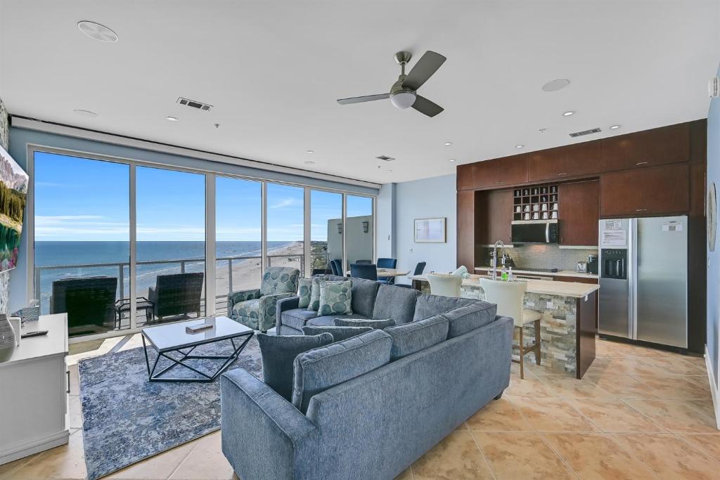 a living room with couches and a kitchen at PH, Balcony, Lazy River, I-O Pools, Game Room, Spa, Beach, Luxury 2-2 Penthouse! in Galveston