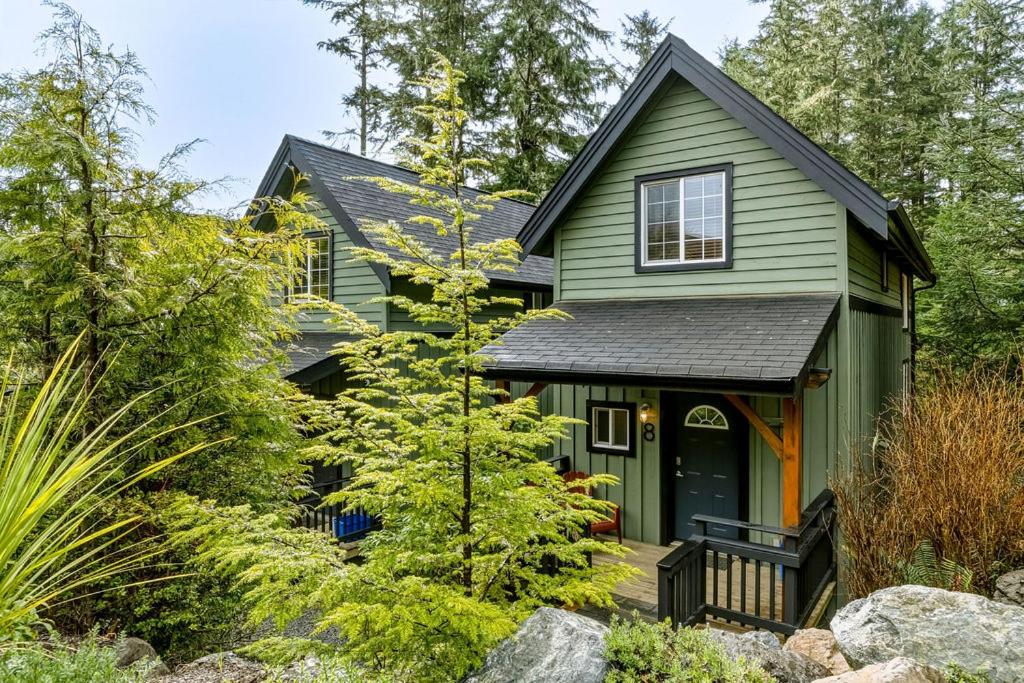 a green house with a black roof at The Cabins at Terrace Beach in Ucluelet