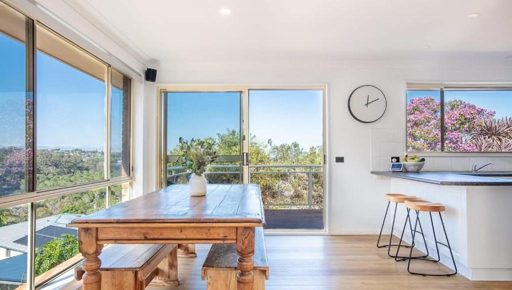 a kitchen with a wooden table and some windows at Sapphire House in Mirador