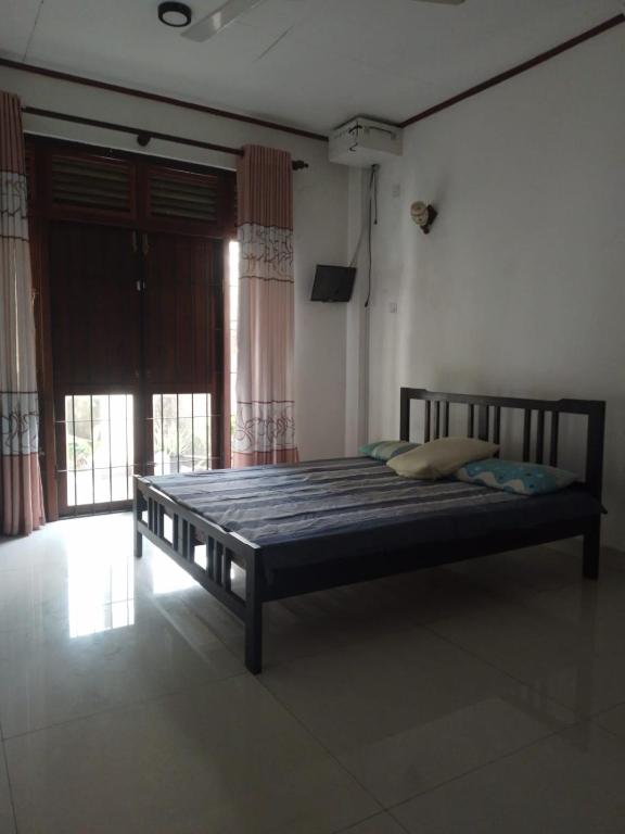 a bed in a room with a large window at Green Haven by Gapper Sri Lanka in Wattala
