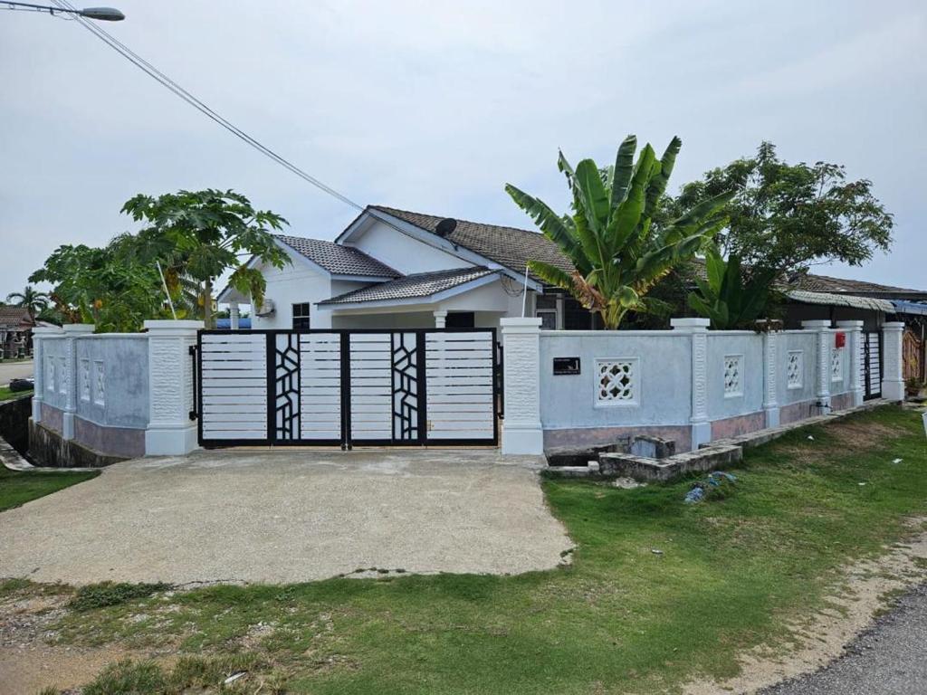 a white house with a gate in front of it at Laman Biru Azalea in Pekan