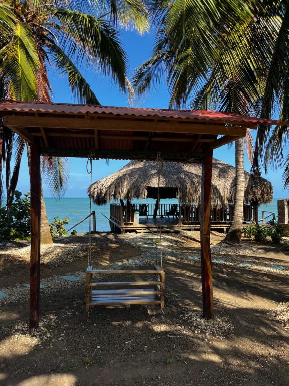 a swing on a beach with a hut at Cabañas Cambaro in Puerto Escondido
