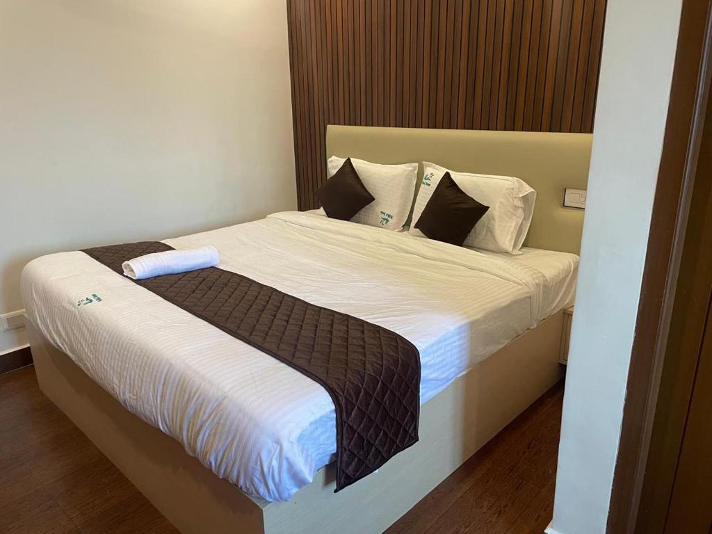 a bedroom with a bed with white sheets and pillows at Niki Inn in Pondicherry