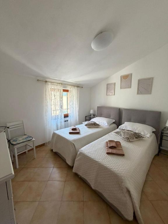 two beds in a bedroom with two towels on them at CA'da LU' in Velva