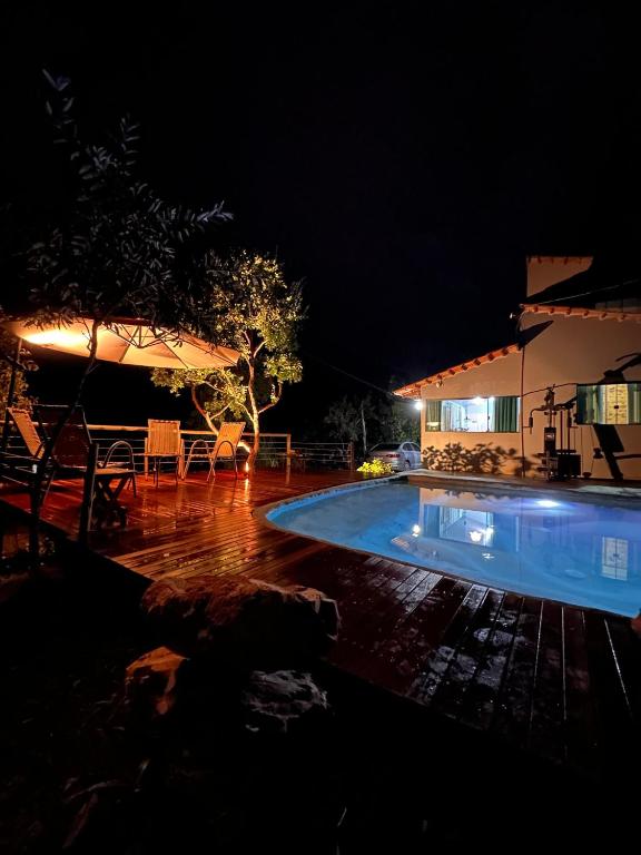 a swimming pool in a yard at night at Casa mussambé in Sao Jorge