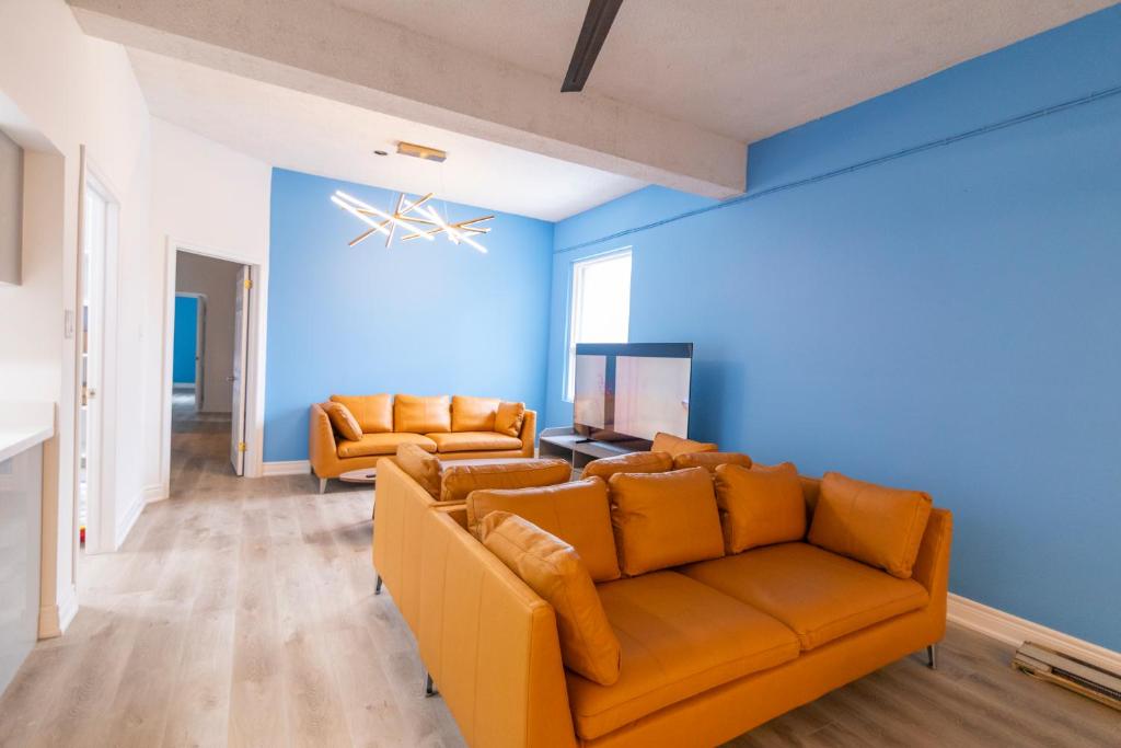 ein Wohnzimmer mit orangefarbenen Möbeln und blauen Wänden in der Unterkunft Check Inn in Toronto