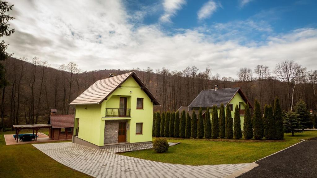 a yellow house with a roof on a yard at Vila Tena in Novo Zvecevo