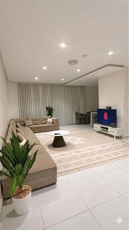 a living room with a couch and a tv at الواحه ريزدنس in Medina