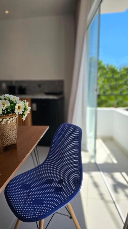 a blue chair sitting in front of a table at Estúdio Arruda in Itacaré