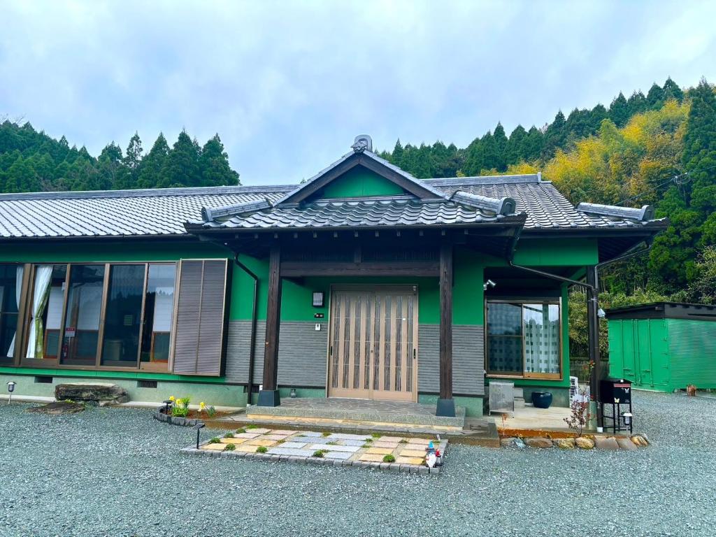 a small house with a green and gray at 蝶自来 in Yamaga