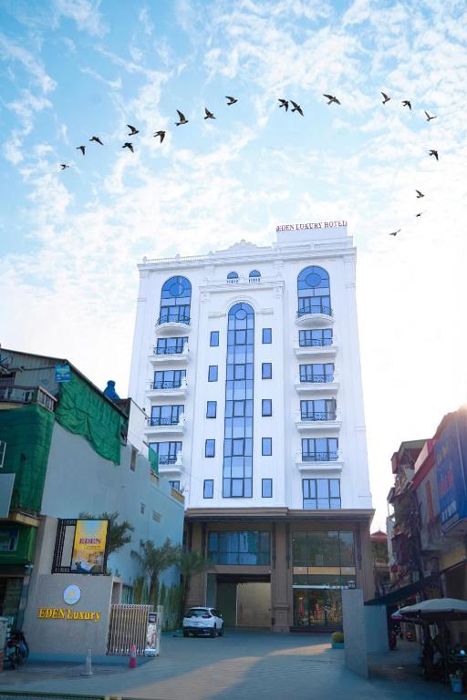 a flock of birds flying over a building at Eden Luxury Hotel in Thái Bình