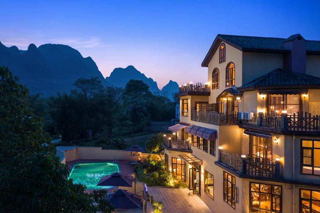 a view of a hotel with mountains in the background at YangShuo Coco Garden Villa-Western food&English Guide in Yangshuo