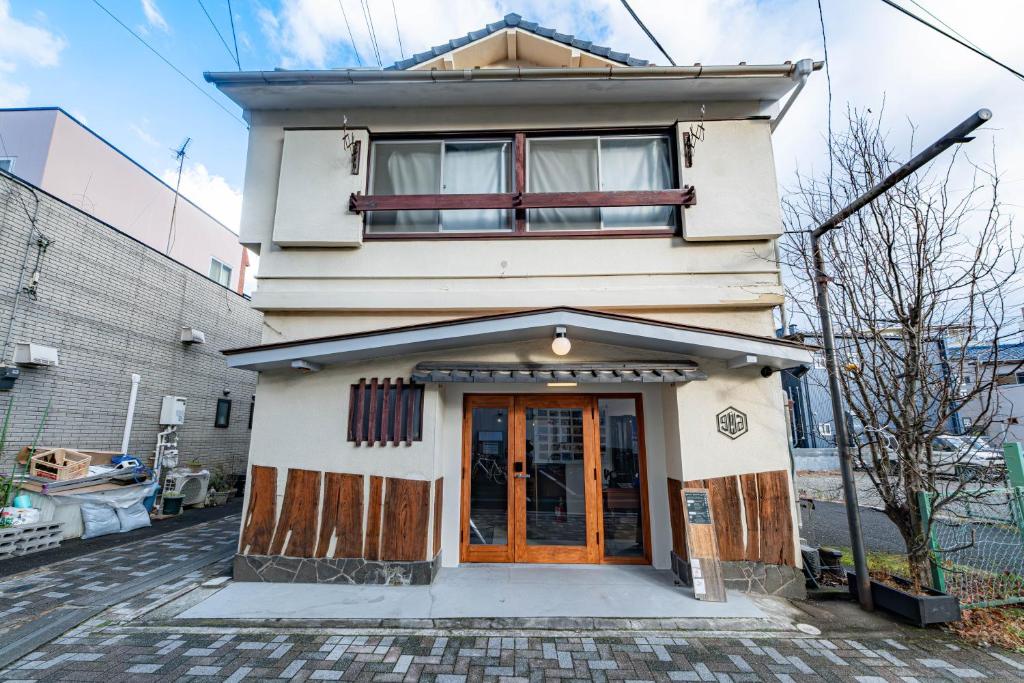 a building with a wooden door in front of it at guest house giwa in Mishima