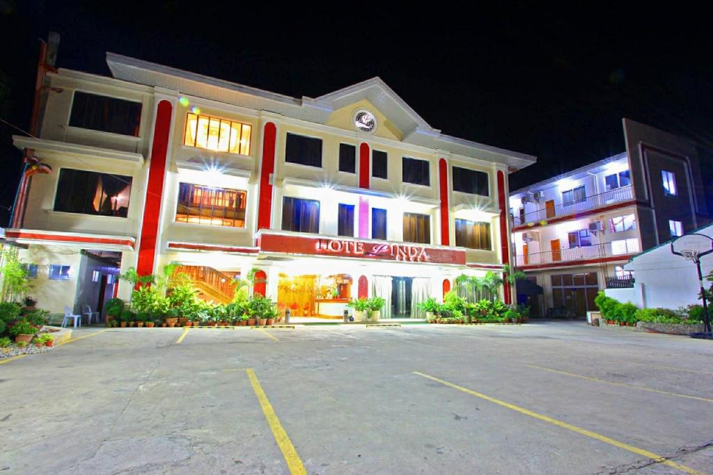 a large building with a parking lot in front of it at HOTELINDA Suites in Vigan