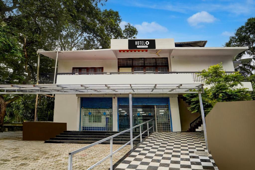 a building with a checkered floor in front of it at Super Hotel O CSIR Pappanamcode Formerly Ambadi Guest House in Poojapura