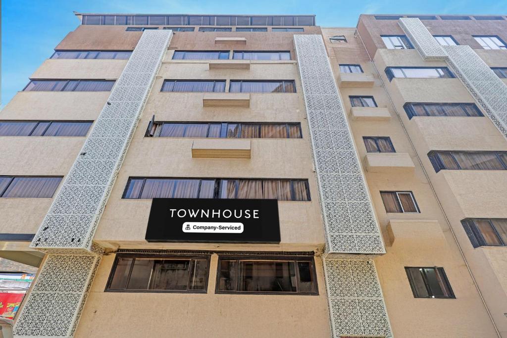 a tall building with a sign for a townhouse at Townhouse Vadodara Railway Station Road Formerly Hotel Raajpath in Vadodara