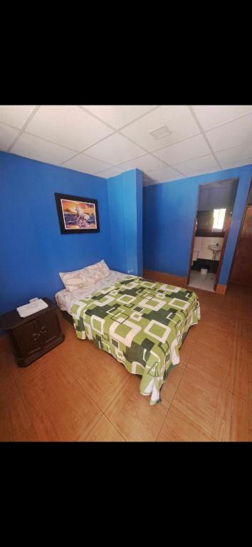 a bedroom with a bed in a blue room at EL BOSQUE Hostal in Chiclayo