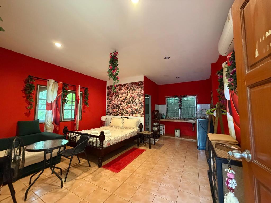 a bedroom with red walls and a bed and a table at Rose bungalow at Ya Nui beach in Nai Harn Beach
