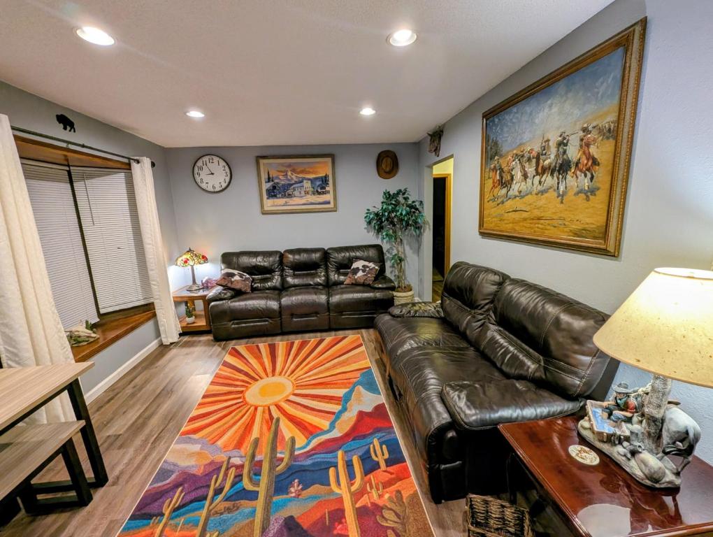 a living room with a leather couch and a table at By State Fair 5 bedrooms 2 baths in Des Moines
