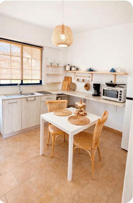a kitchen with a white table and chairs at Afroditi Junior Suites in Archangelos