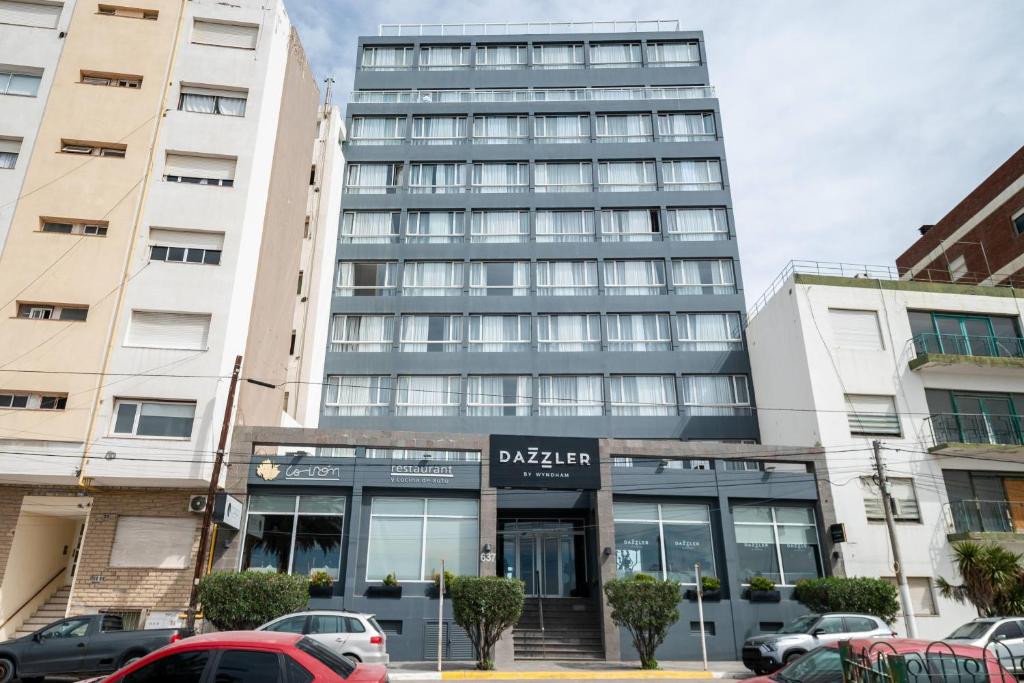 a tall building with cars parked in front of it at Dazzler by Wyndham Puerto Madryn in Puerto Madryn