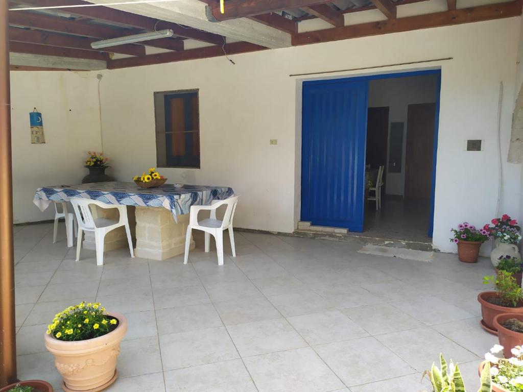 a patio with a table and chairs and a blue curtain at Tra mare e relax in Favignana