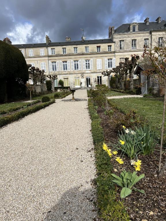 a large building with a garden in front of it at Le jardin de L'Hippodrome in Chantilly