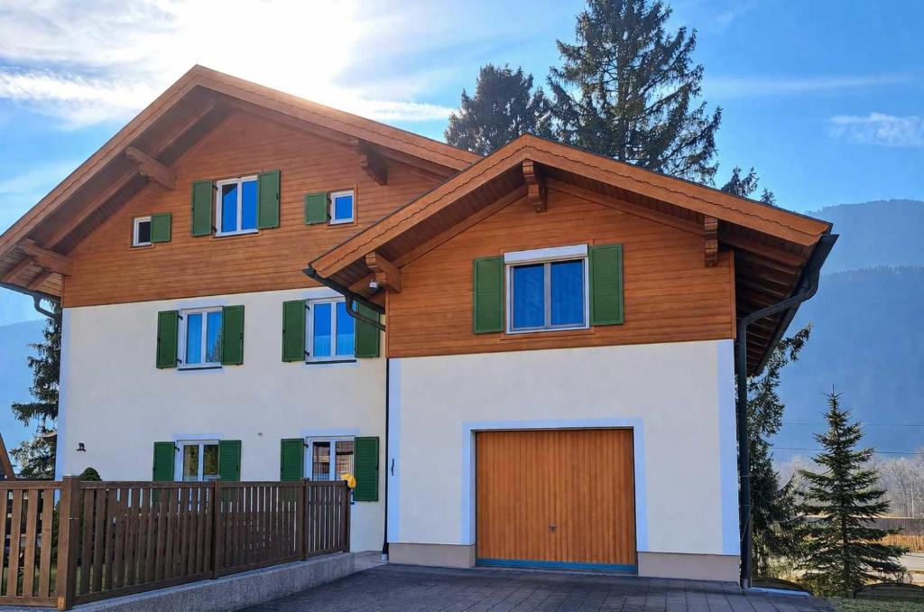 a house with a wooden roof and a garage at Ferienwohnung mit Küche & kleines Gästezimmer Lisi ohne Küche im Obergeschoß - 2 separate Einheiten - nahe Salzburg, ideal für Familien & Durchreise in Kuchl