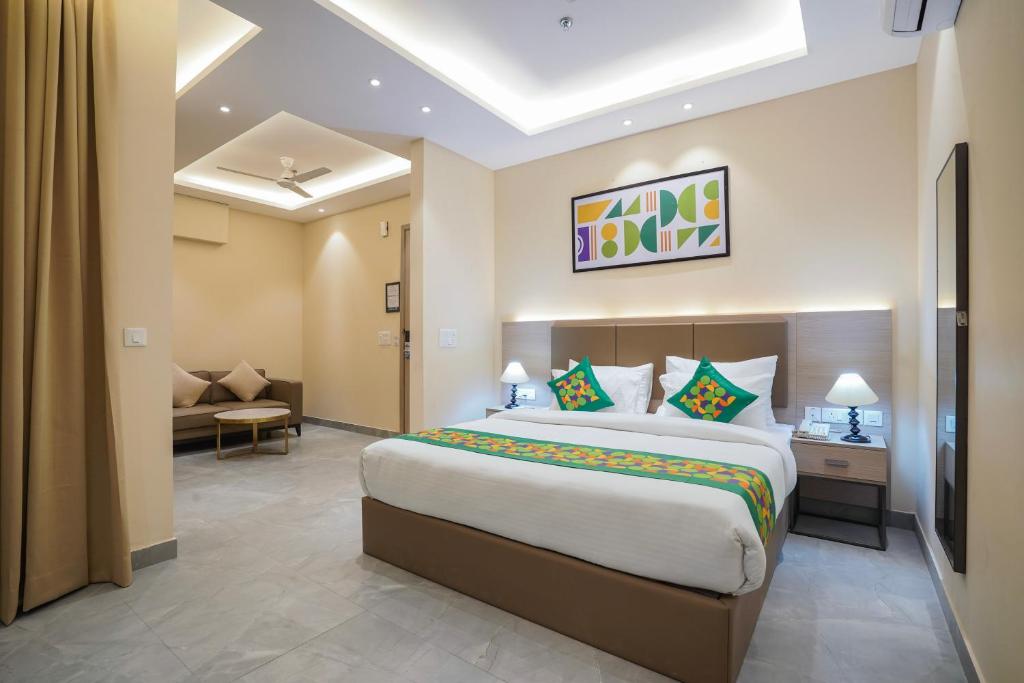 a bedroom with a large bed and a living room at Treebo Premium Indus Crown in Noida