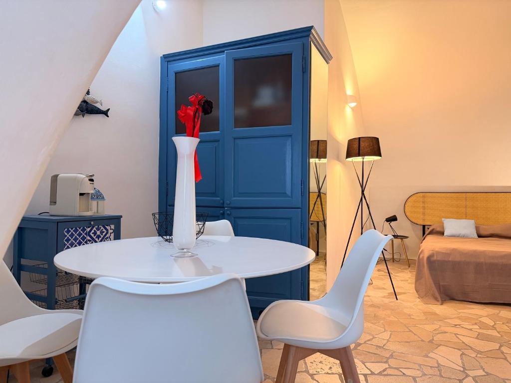 a white table with chairs and a vase with a red rose at Suite Del Borgo in Gallipoli