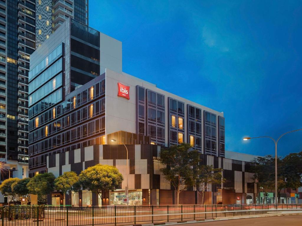 a building with a red sign on the side of it at Ibis Singapore Novena in Singapore
