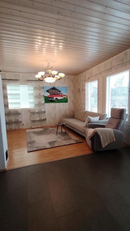 a living room with a couch and two windows at kelankaari in Kankaanpää