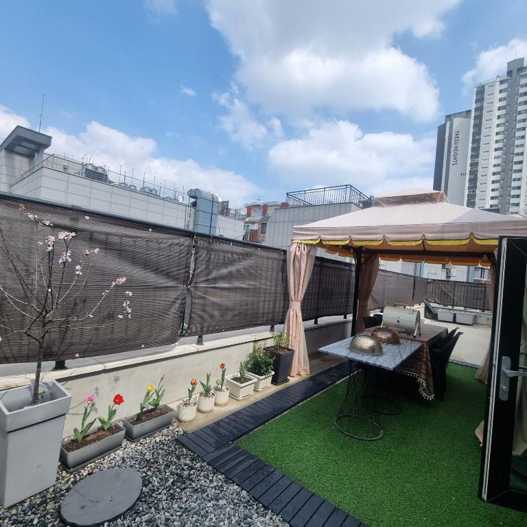 a rooftop patio with a gazebo on a building at YYStay 감성 루프탑 in Seoul