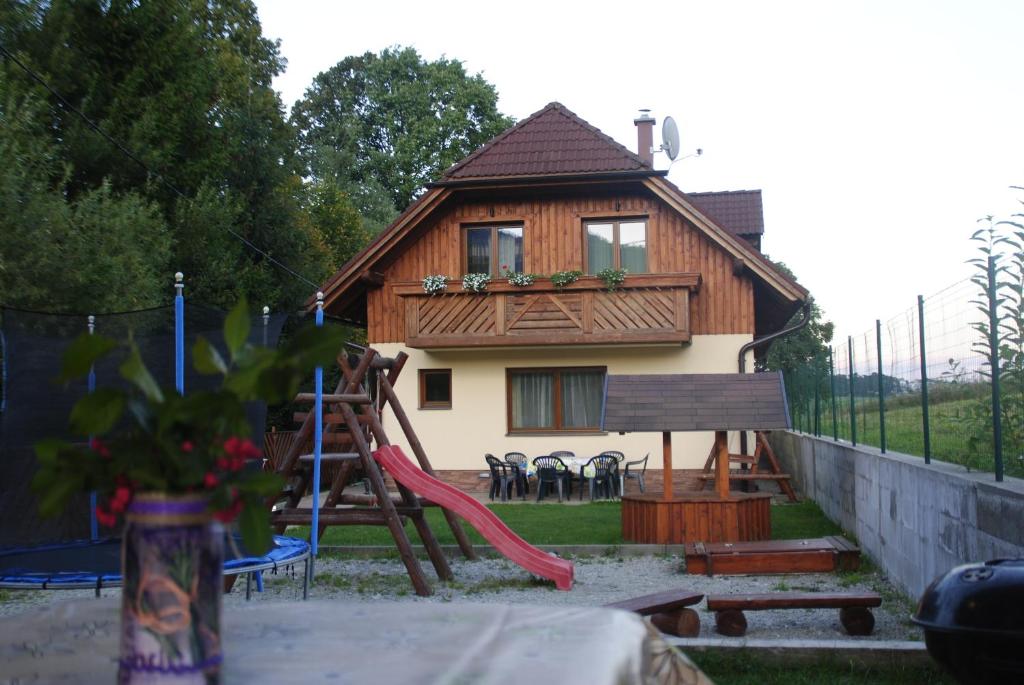 una pequeña casa con un tobogán y un parque infantil en Dom Dorota, en Liptovská Sielnica