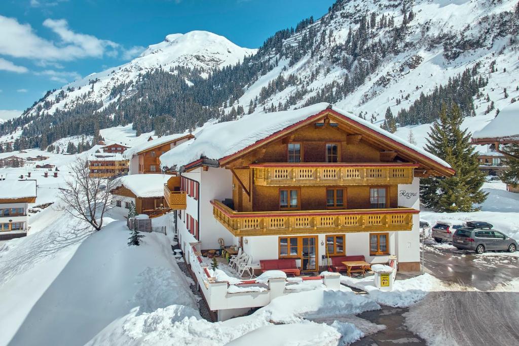 a ski lodge in the mountains with snow on the ground at Pension Regina in Lech am Arlberg