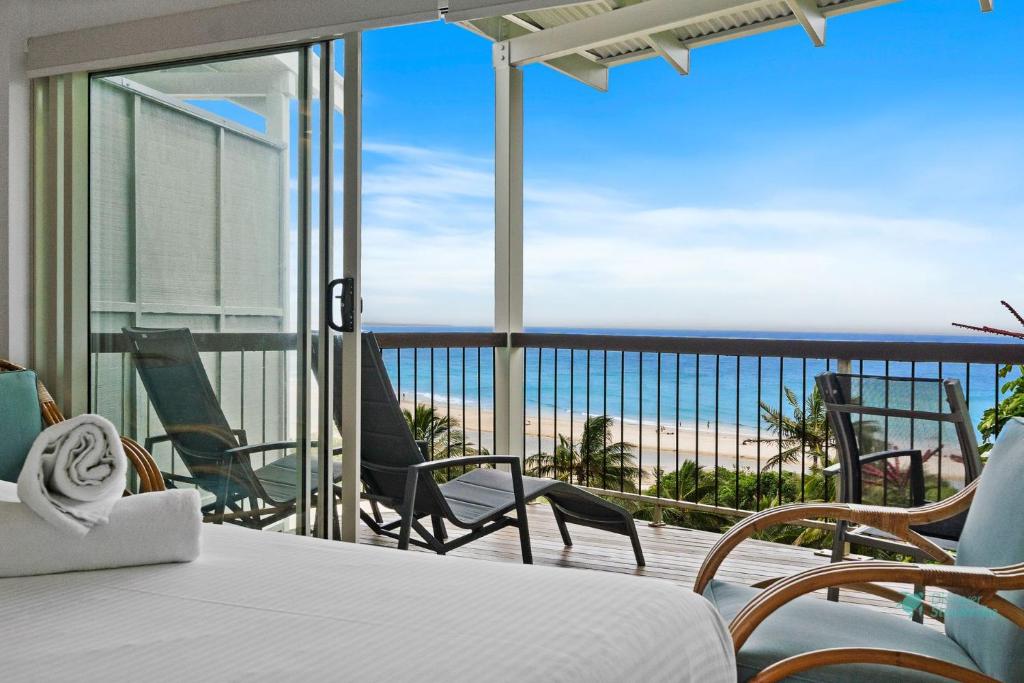 a bedroom with a balcony with a view of the ocean at Cylinder Cove 9 in Point Lookout