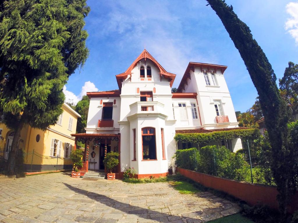 una gran casa blanca con una valla alrededor en Pousada Imperial Koeler, en Petrópolis