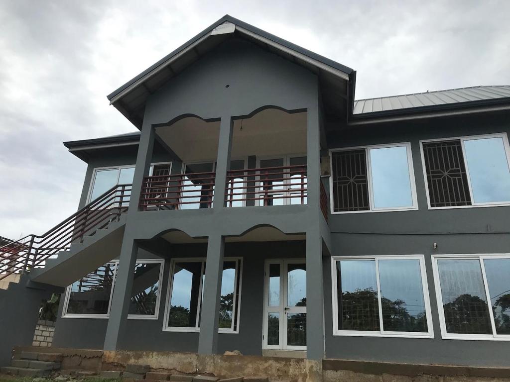 a large house with glass doors and windows at Rainbow Palace Apartment in Sekondi-Takoradi