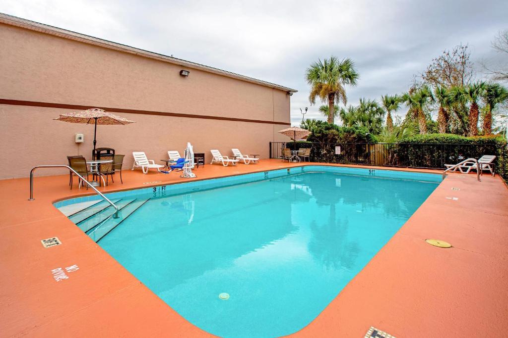 a large swimming pool with chairs and an umbrella at Quality Inn & Suites Live Oak I-10 Exit 283 in Live Oak