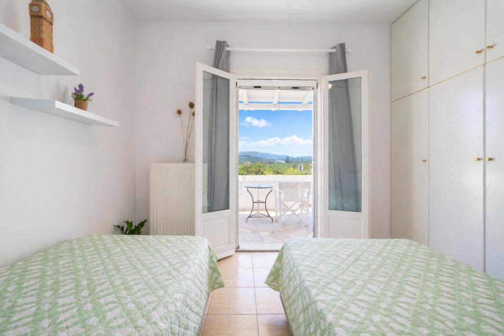 a bedroom with two beds and a door to a patio at Pounda Breeze in Pounda
