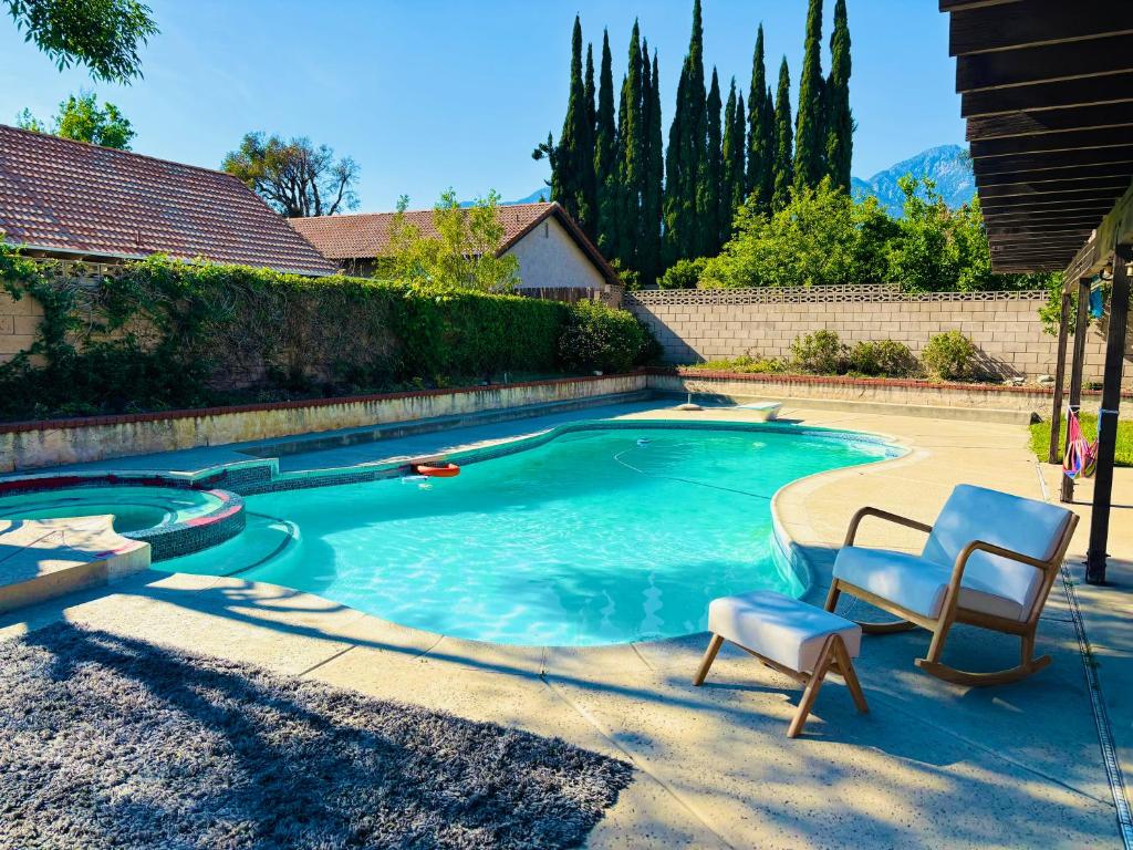 a swimming pool with two chairs in a yard at Joshie home in Rancho Cucamonga