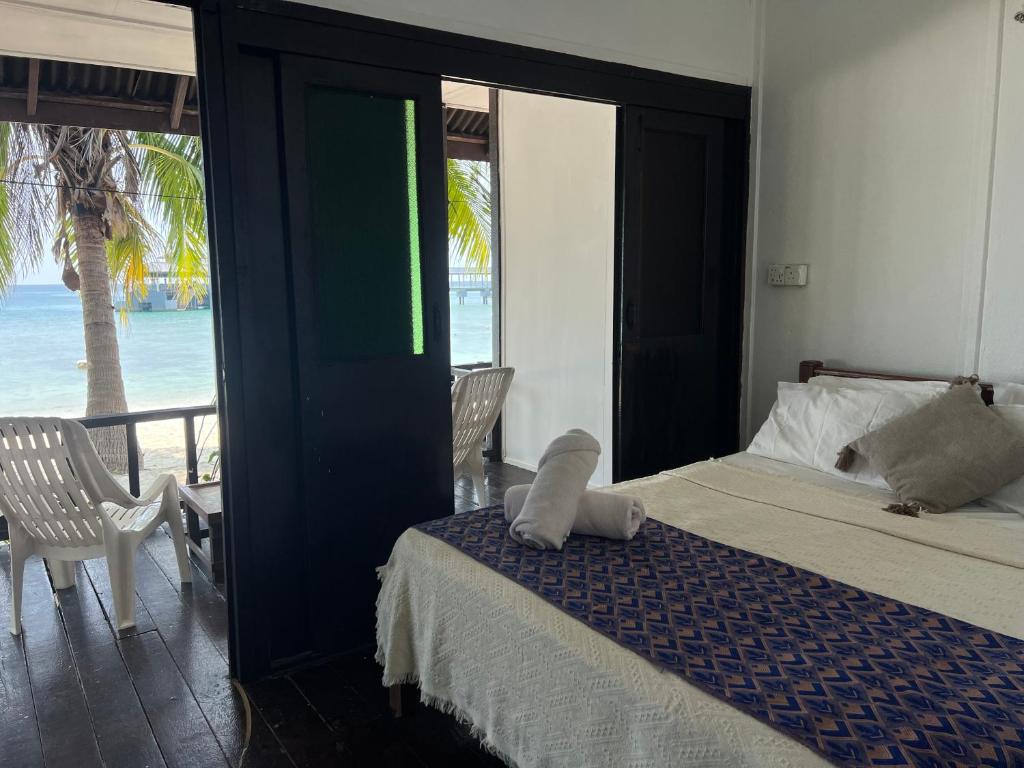a bedroom with a bed and a view of the ocean at Maya Seaview Chalet, Coral Bay Perhentian Island in Perhentian Island